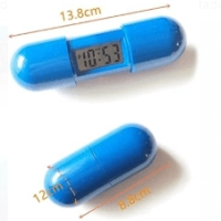 Reloj con Alarma en ABS en forma de pildora, abierto 13.8 x 1.2 cmts, cerrado 8.8
